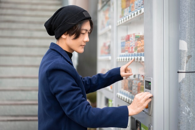 Side view of man ordering from vending machine