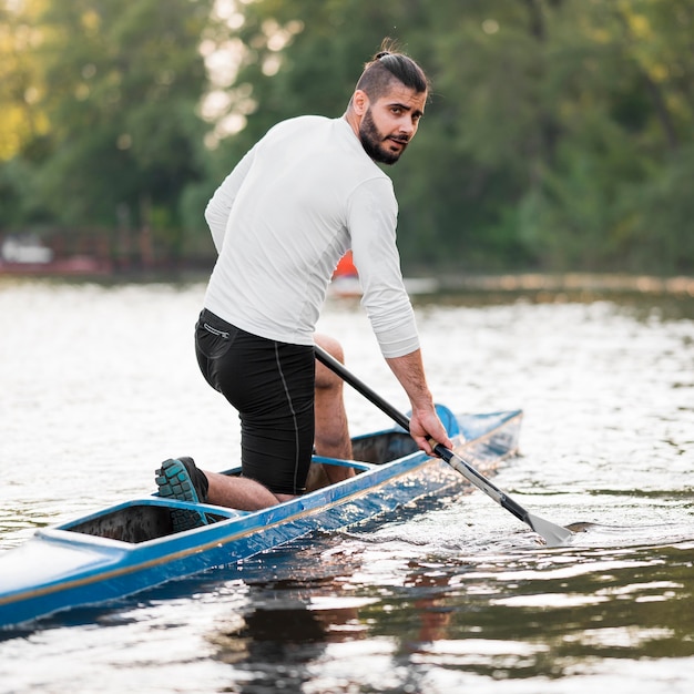 Side view man paddling in canoe