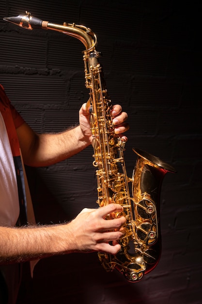 Free photo side view of man playing saxophone