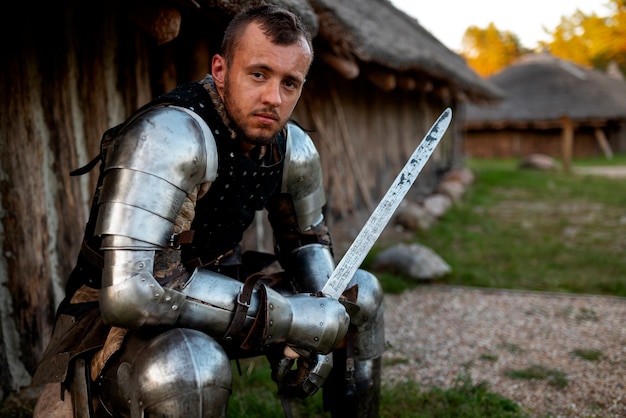 Side view man posing as a medieval soldier