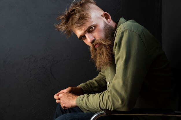 Side view man posing on chair