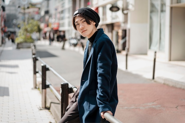 Free Photo side view of man posing while sitting on railings