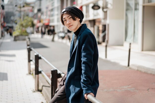 Side view of man posing while sitting on railings