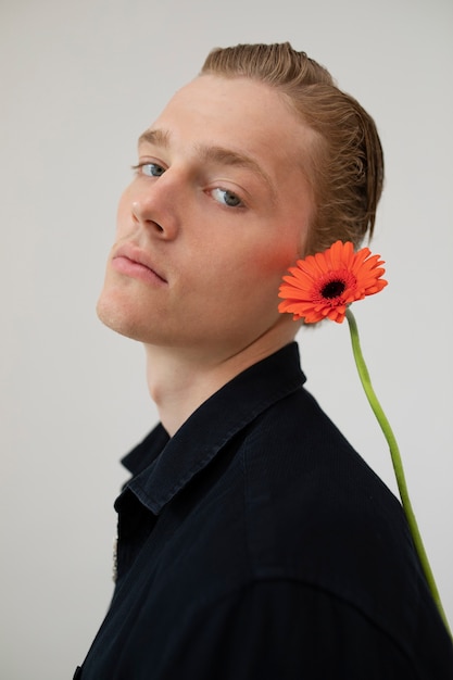 Free photo side view man posing with flower