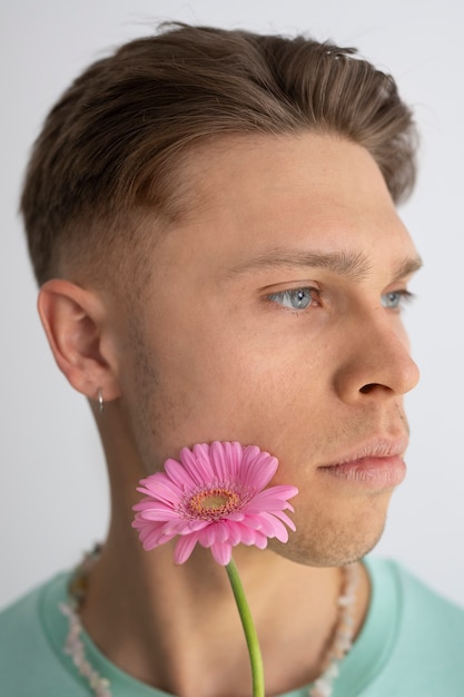 Side view man posing with pink flower