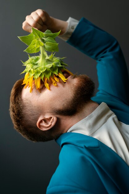 Side view man posing with sunflowers