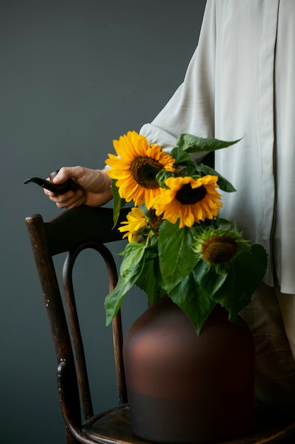 Free photo side view man posing with sunflowers