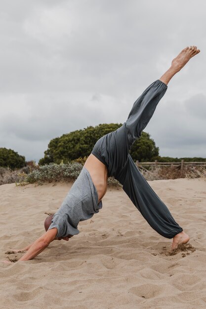 Side view of man practicing yoga outdoors