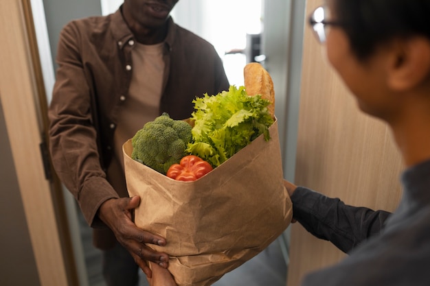 Side view man receiving groceries