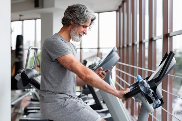 Side view man running at gym