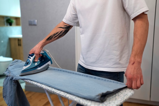 Side view man servant ironing pants