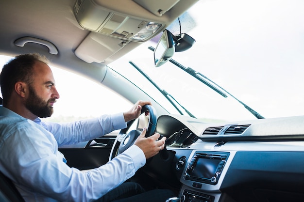 Side view of a man sitting inside car