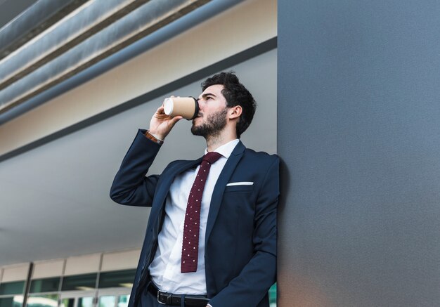 Side view man in suit drinking coffee