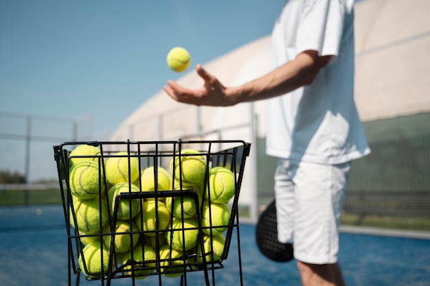 Side view man taking ball from container