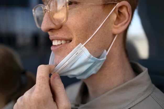 Side view man  taking mask off