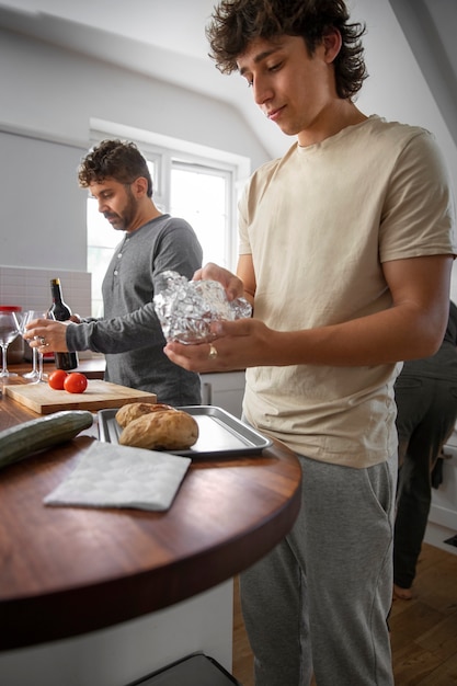 Free Photo side view man and teen cooking