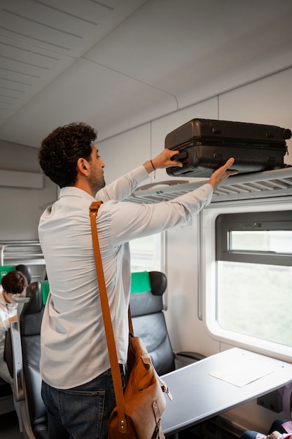 Free photo side view man traveling by train