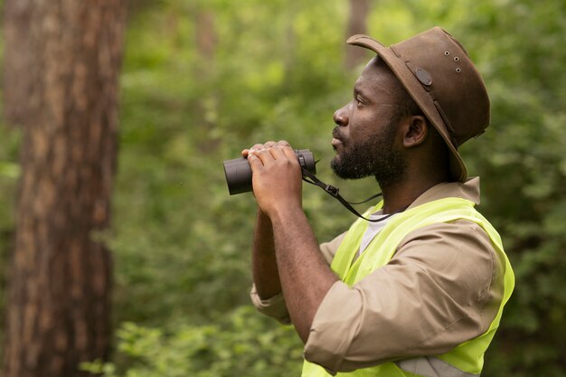 Side view man using binoculars