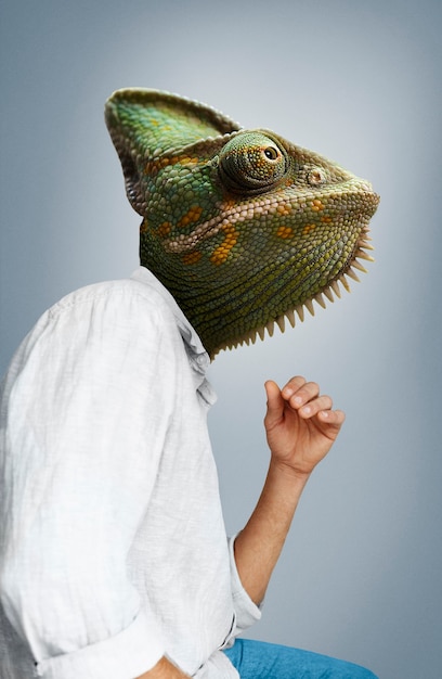 Free Photo side view man wearing chameleon head