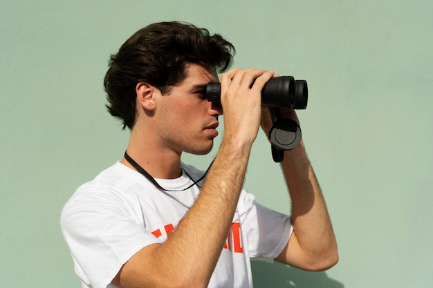 Free photo side view man with binoculars