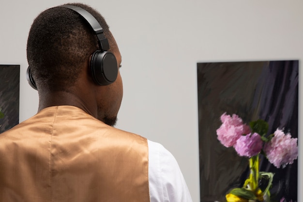 Side view man with headphones at art gallery