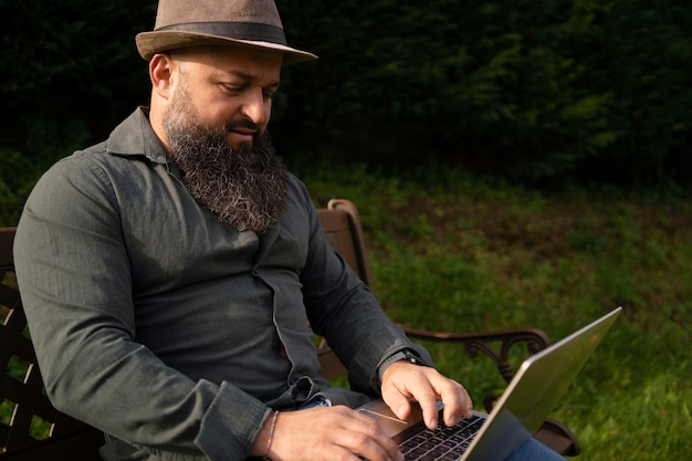 Side view man with laptop outdoors