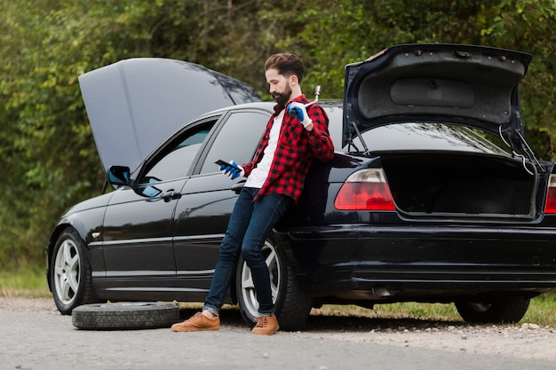 Free photo side view of man with phone and wrench