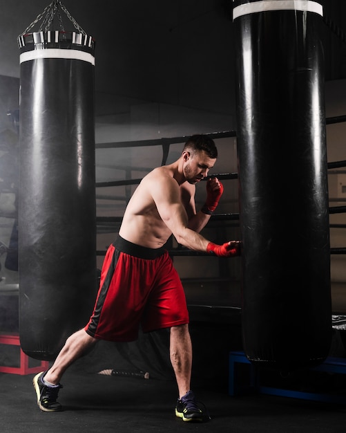 Side view man with red gloves boxing