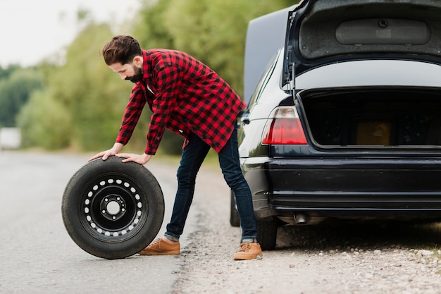 Free photo side view of man with spare tyre