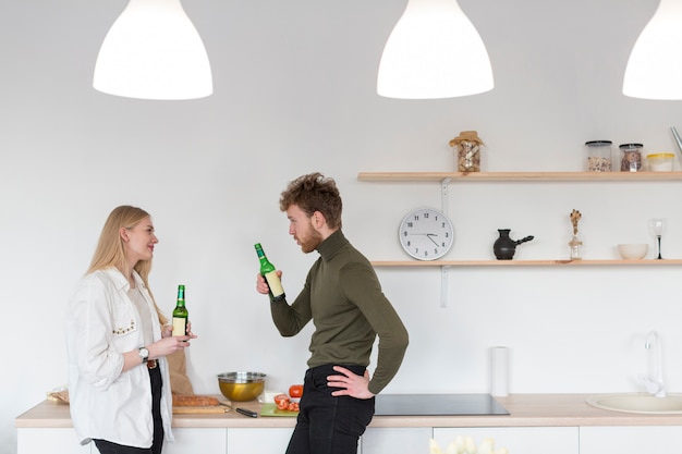 Side view man and woman enjoying beer together