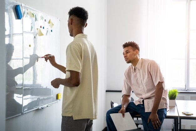 Side view man writing on whiteboard