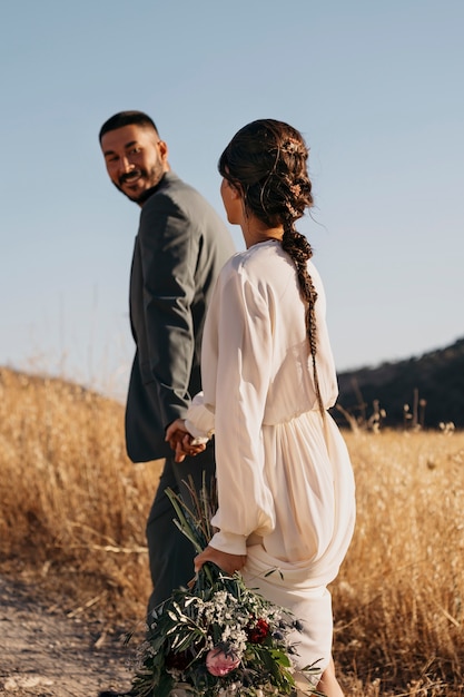 Free photo side view married couple walking outdoors