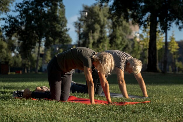 Side view of mature couple doing yoga outdoors