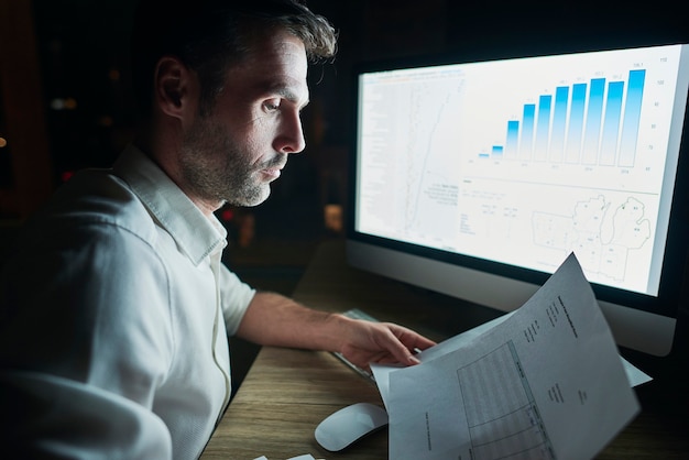 Free photo side view of mature man analyzing documents at night