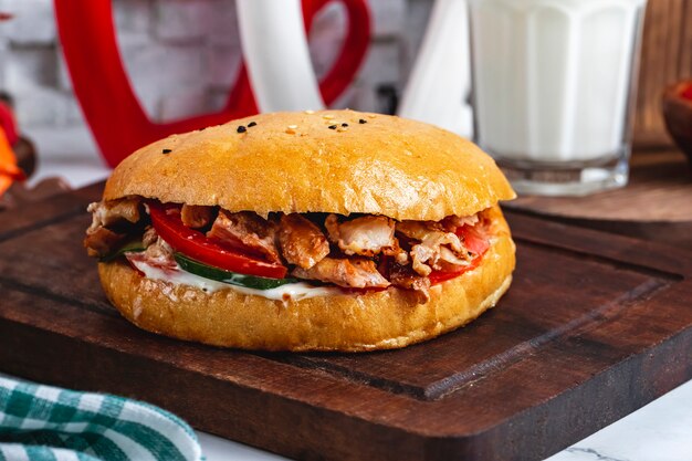 Side view meat doner in bread on a board