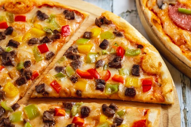 Side view meat pizza with red yellow and green peppers meat and cheese