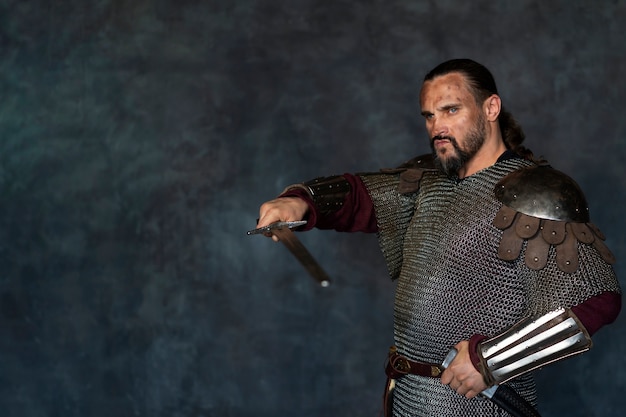 Free photo side view medieval soldier posing in studio