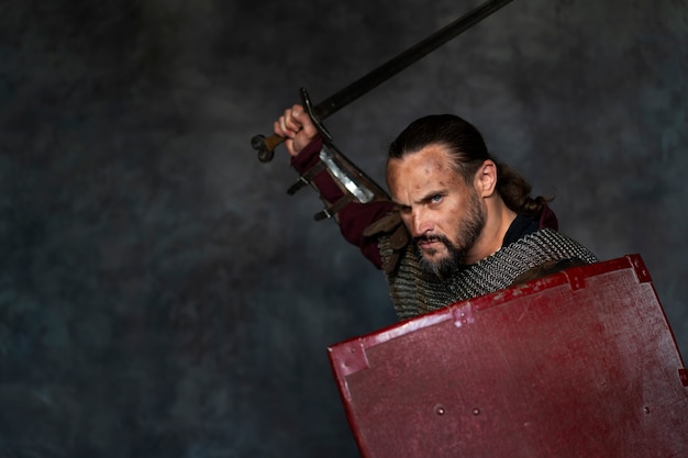 Free Photo side view medieval soldier posing in studio