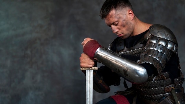 Free Photo side view medieval soldier posing in studio