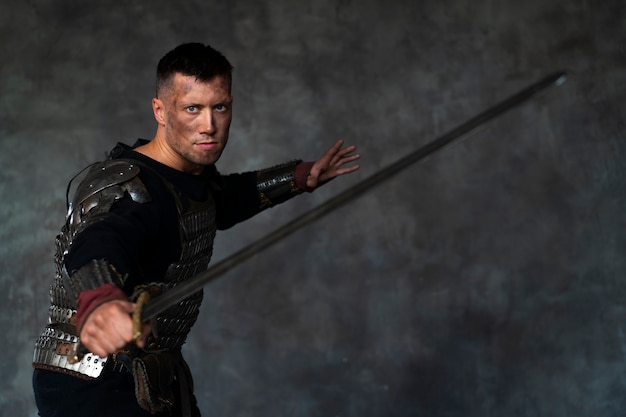 Free photo side view medieval soldier posing in studio