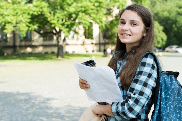 Side view medium shot of school girl holding notes