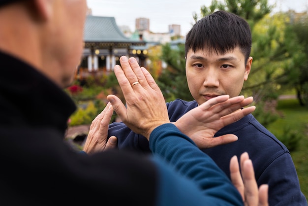 Side view men practicing tai chi outside