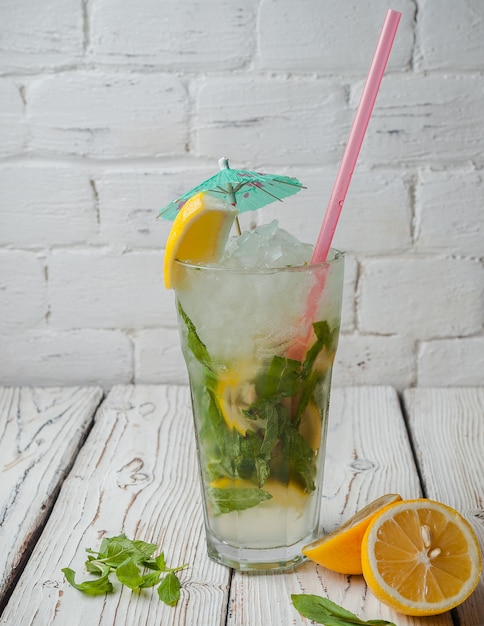 Free Photo side view mojito with lemon and juice strawmint in glass cup