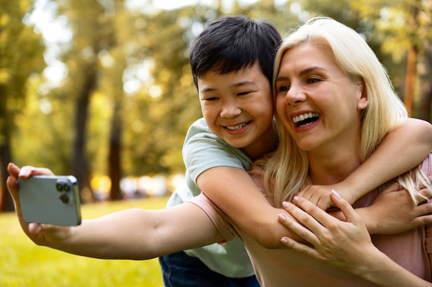 Side view mother and boy taking selfie