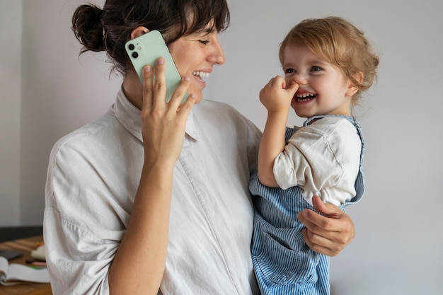 Free photo side view mother holding smiley little girl