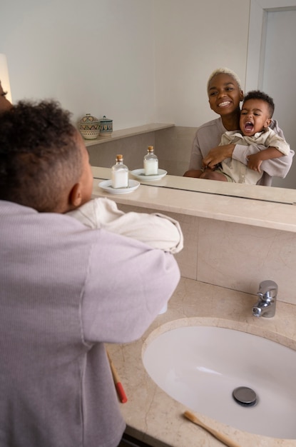 Free Photo side view mother and kid in bathroom