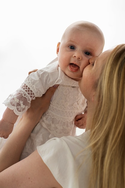 Side view mother kissing baby on cheek