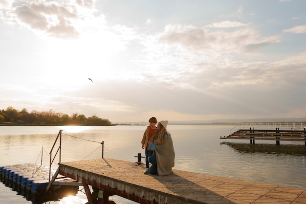 Free photo side view mother and son hanging out on a jetty