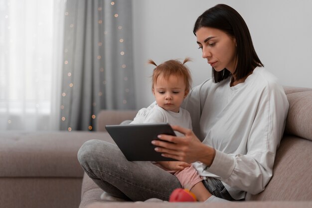 Side view mother with tablet and baby