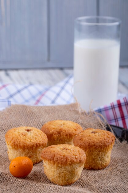 Side view of muffins and a glass of milk on the table